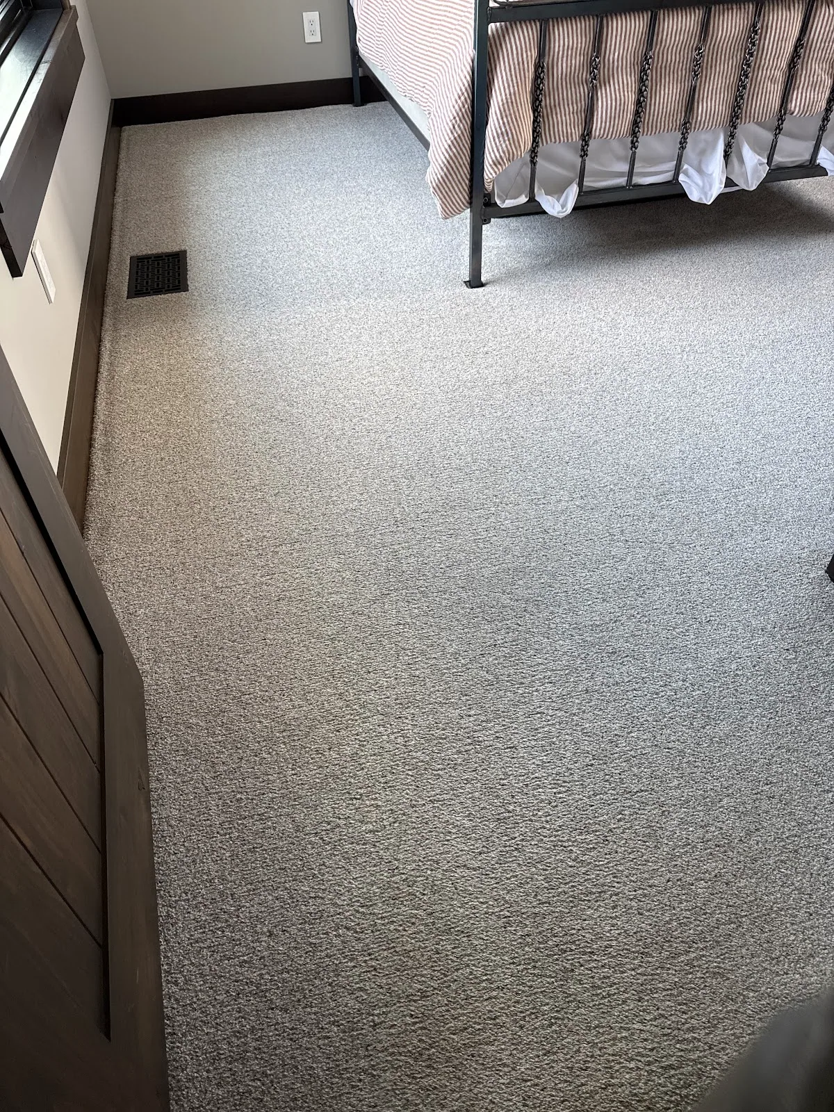 Cleaned gray bedroom carpet beside a metal bed frame