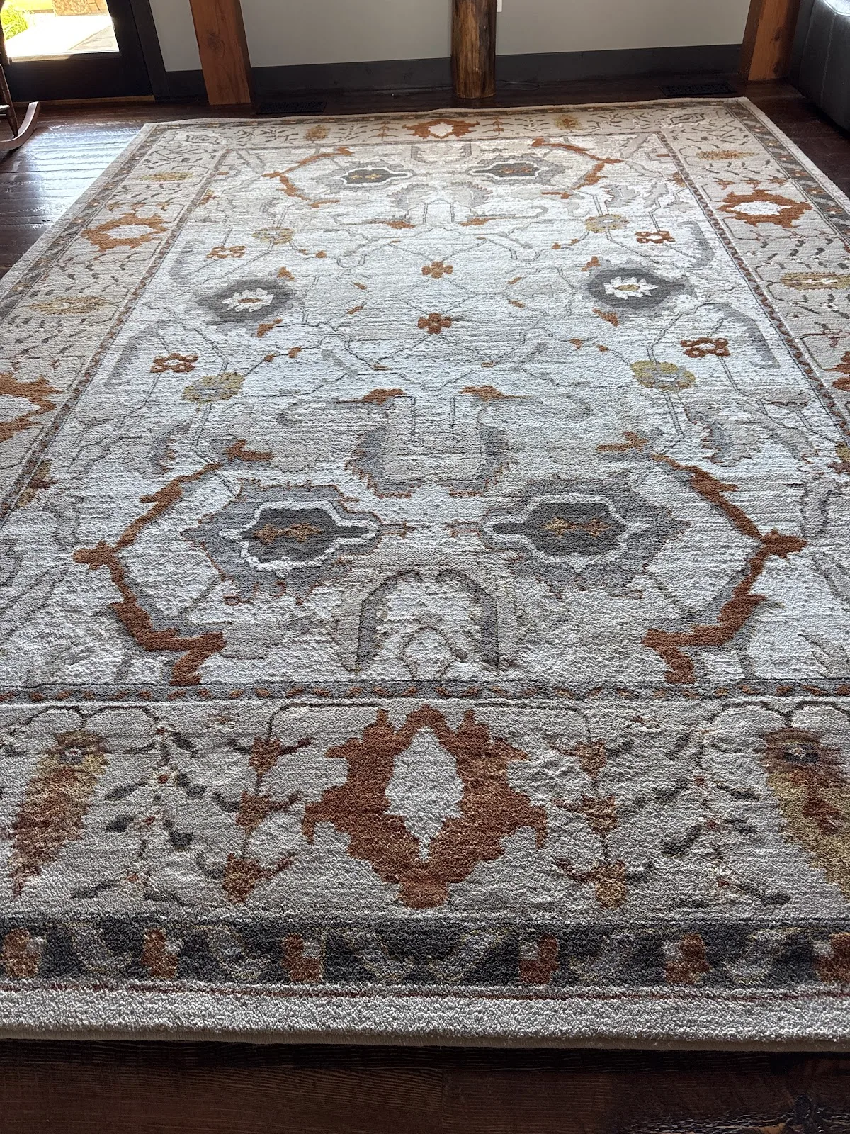 A freshly cleaned ornate cream and rust area rug