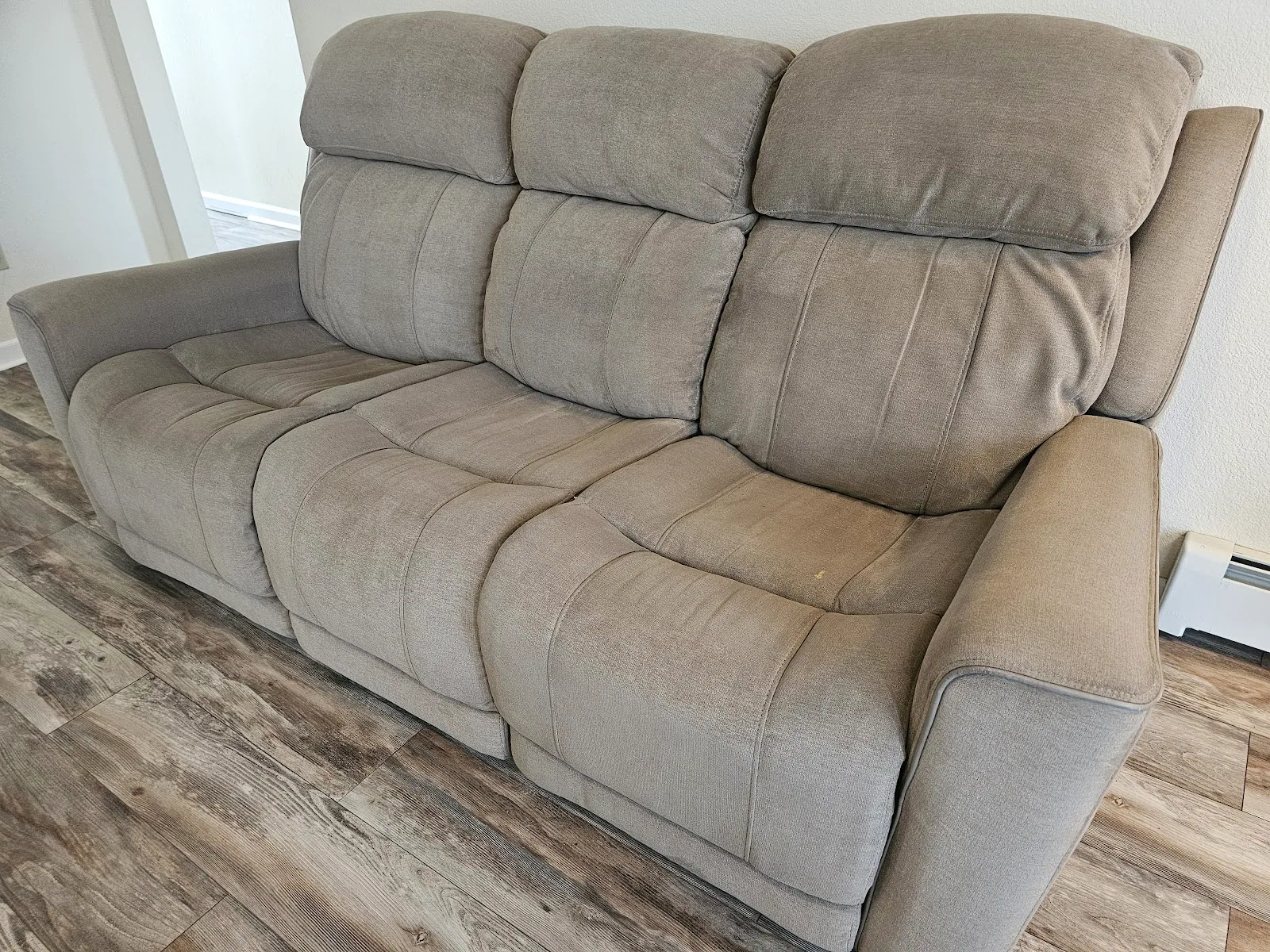 A freshly cleaned gray fabric reclining sofa after upholstery cleaning