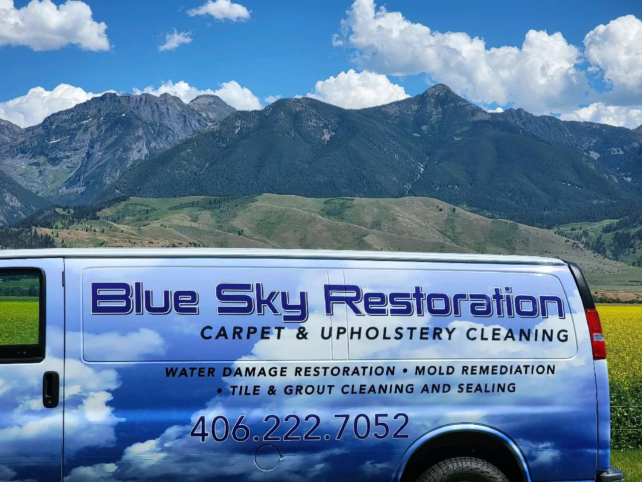 The Blue Sky Restoration van in front of the Montana mountains
